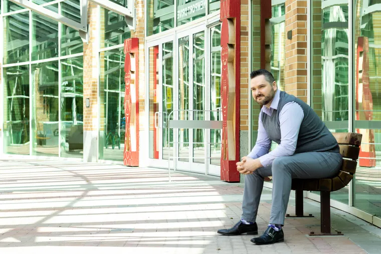 Callan Morrison standing beside the Port Moody city welcome sign.
